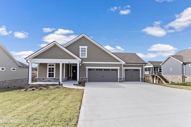 craftsman house featuring a garage, a porch, and a front lawn