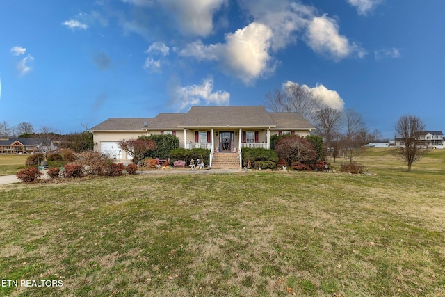 ranch-style home featuring a garage, a front yard, and covered porch