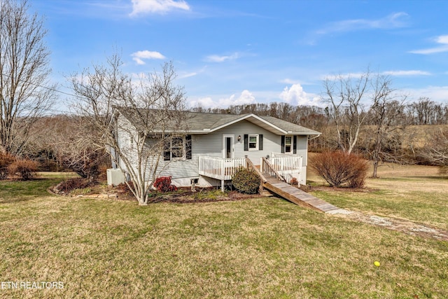 ranch-style house featuring roof with shingles, a deck, and a front yard