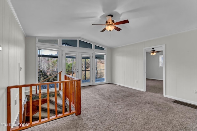 carpeted spare room with visible vents, baseboards, vaulted ceiling, french doors, and ornamental molding