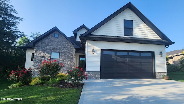 craftsman inspired home with a garage, stone siding, concrete driveway, and a front lawn