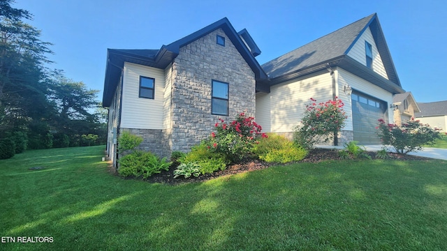 view of side of home featuring stone siding, a yard, and concrete driveway