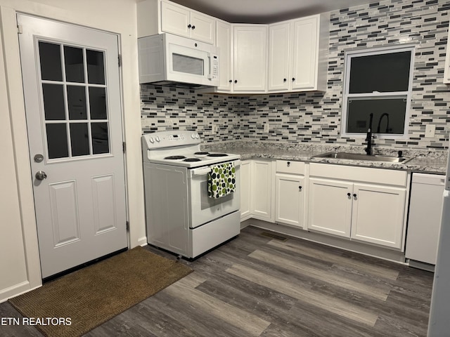 kitchen with dark hardwood / wood-style floors, sink, white cabinets, light stone counters, and white appliances