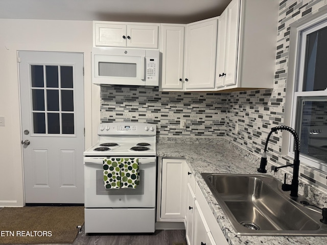 kitchen with white cabinetry, sink, backsplash, and white appliances