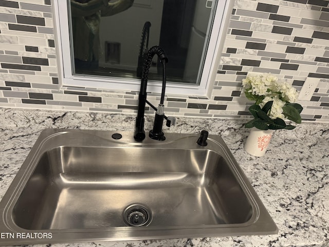 room details featuring sink and decorative backsplash