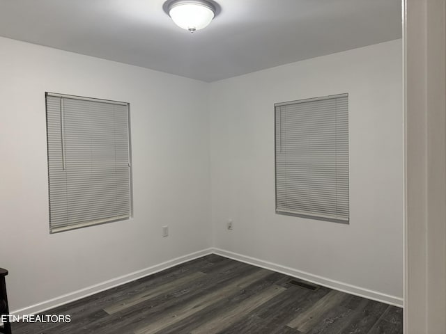 spare room featuring dark wood-type flooring