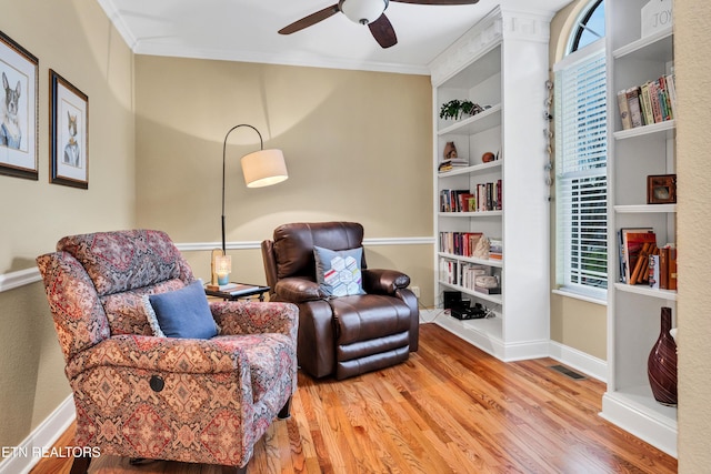 sitting room featuring crown molding, wood-type flooring, and a wealth of natural light