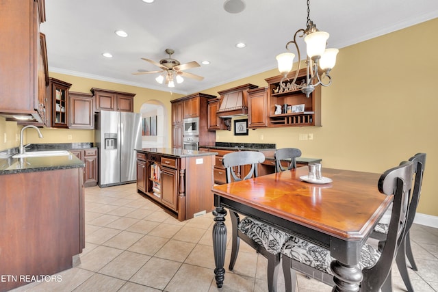 kitchen with ornamental molding, appliances with stainless steel finishes, a center island, and sink