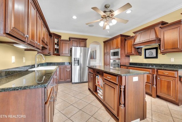 kitchen featuring light tile patterned flooring, sink, crown molding, appliances with stainless steel finishes, and a kitchen island