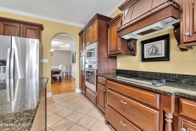 kitchen with light tile patterned floors, crown molding, custom exhaust hood, and appliances with stainless steel finishes