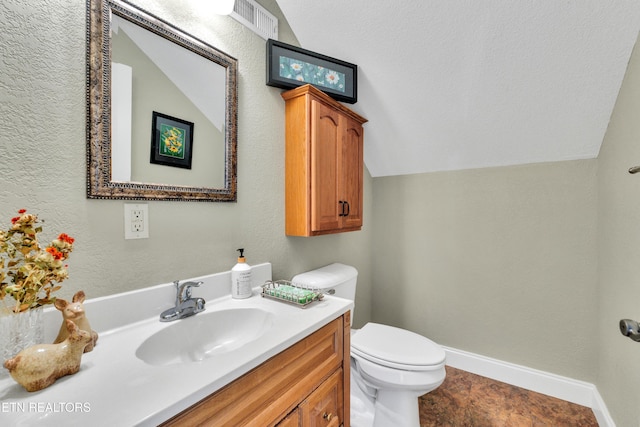 bathroom featuring lofted ceiling, vanity, and toilet