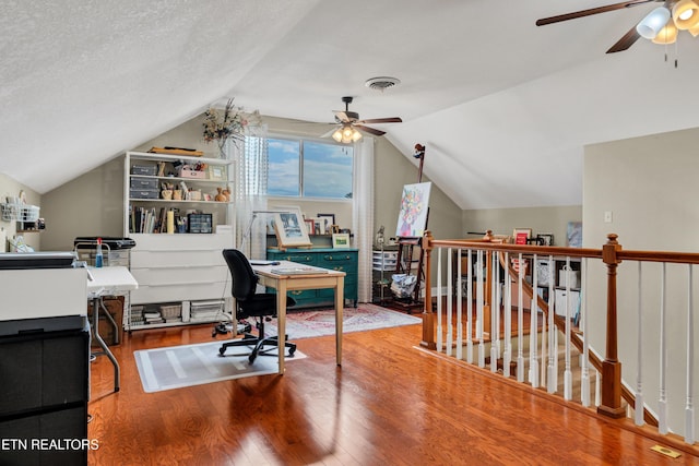 office space with hardwood / wood-style floors, vaulted ceiling, a textured ceiling, and ceiling fan