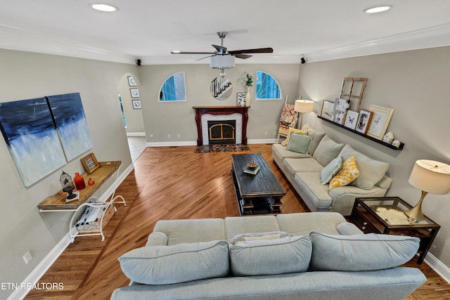 living room with ornamental molding, hardwood / wood-style floors, and ceiling fan