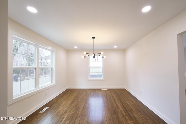 unfurnished dining area with dark hardwood / wood-style floors and a notable chandelier