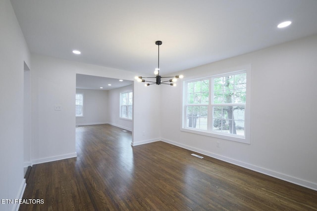 interior space with dark wood-type flooring and a chandelier