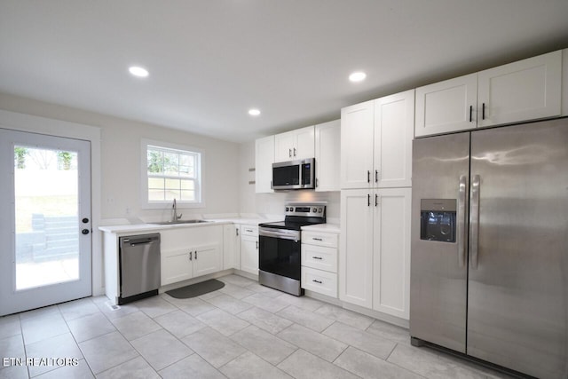 kitchen featuring appliances with stainless steel finishes, sink, and white cabinets