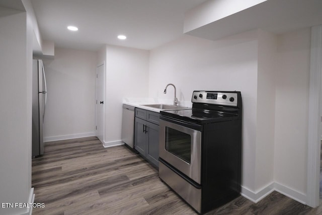 kitchen with stainless steel appliances, sink, dark wood-type flooring, and gray cabinets