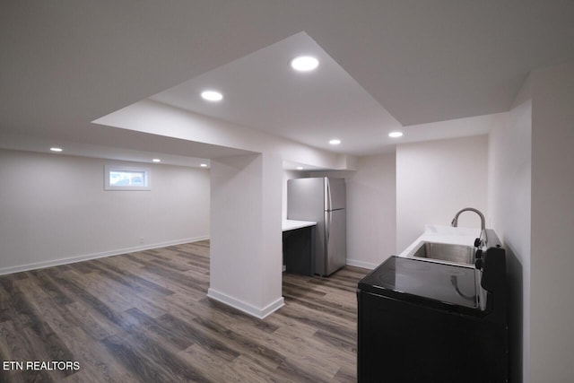 interior space with washer / dryer, sink, dark wood-type flooring, and stainless steel fridge