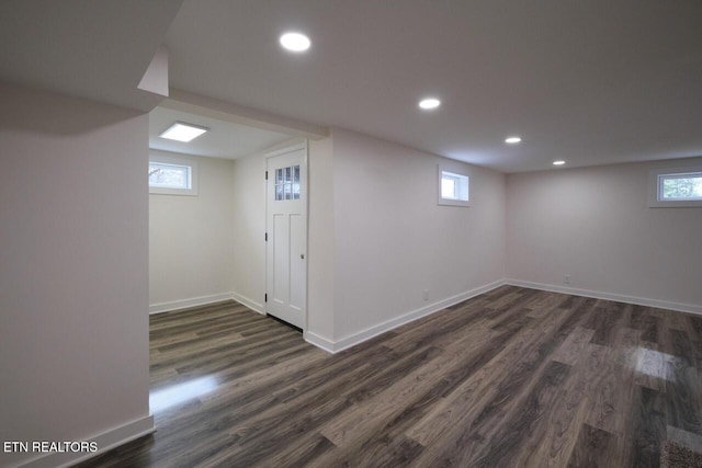 basement with dark hardwood / wood-style flooring and a healthy amount of sunlight