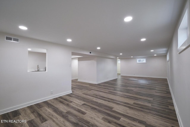 basement featuring dark hardwood / wood-style floors and sink