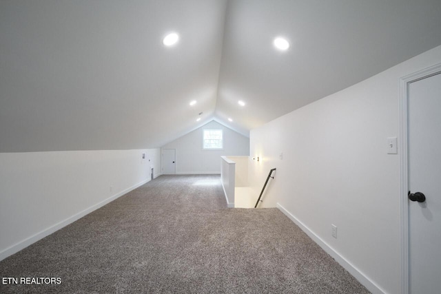 additional living space featuring carpet floors and vaulted ceiling