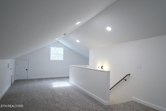 bonus room with lofted ceiling and carpet flooring