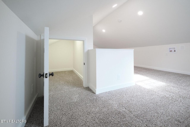 additional living space featuring light colored carpet and lofted ceiling