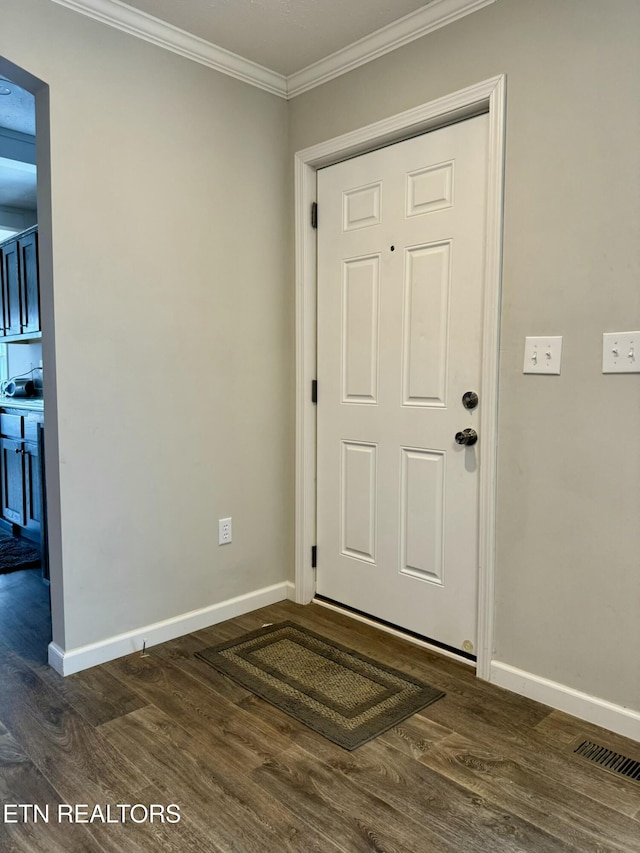 foyer entrance featuring crown molding, visible vents, baseboards, and dark wood-type flooring