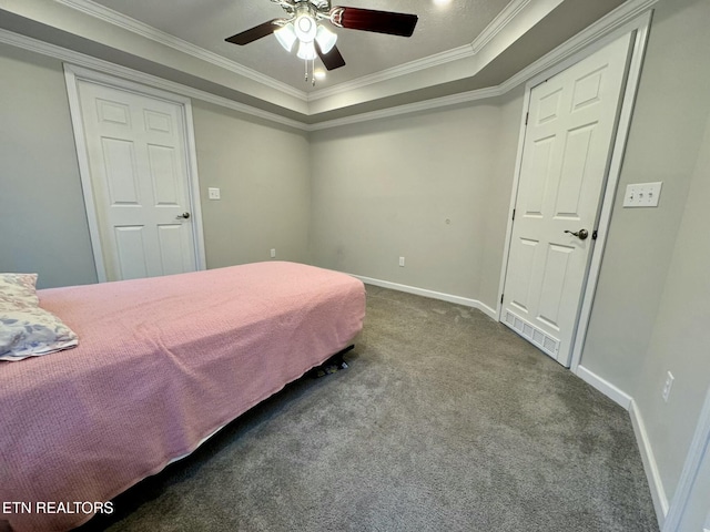 bedroom with carpet, a tray ceiling, crown molding, a ceiling fan, and baseboards