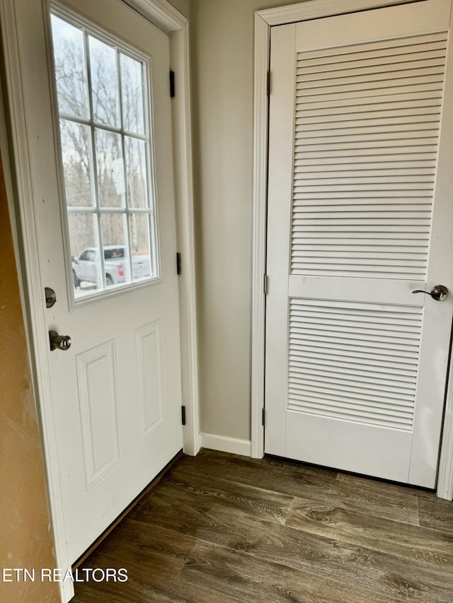 entryway with dark wood-style flooring and baseboards