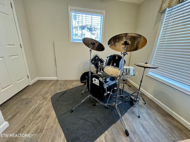 exercise area with wood finished floors and baseboards