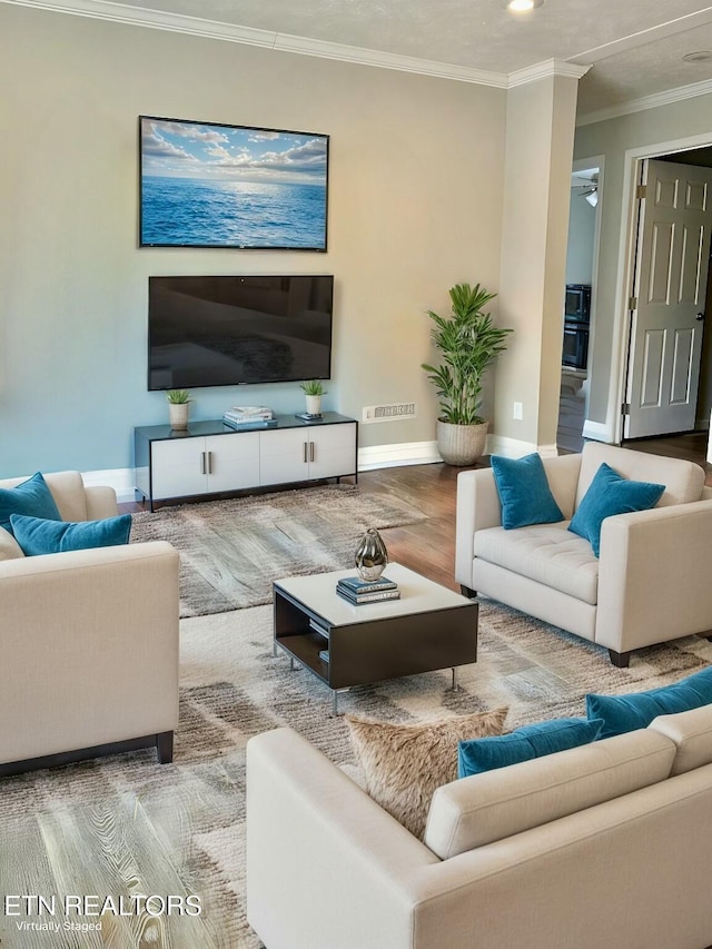 living area featuring baseboards, visible vents, and ornamental molding