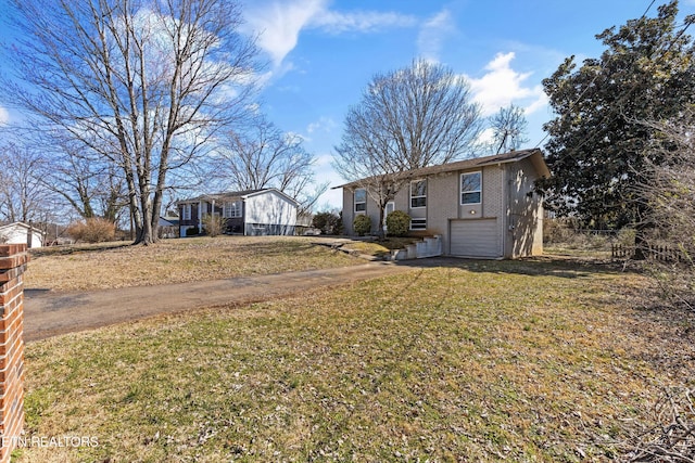 raised ranch featuring a front lawn, brick siding, an attached garage, and dirt driveway