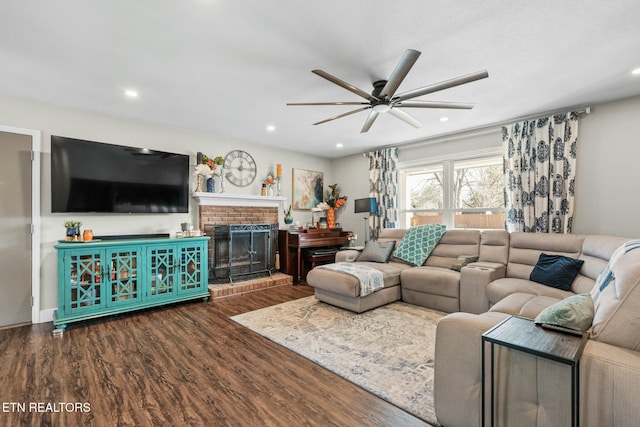 living room featuring ceiling fan, a fireplace, and dark hardwood / wood-style flooring