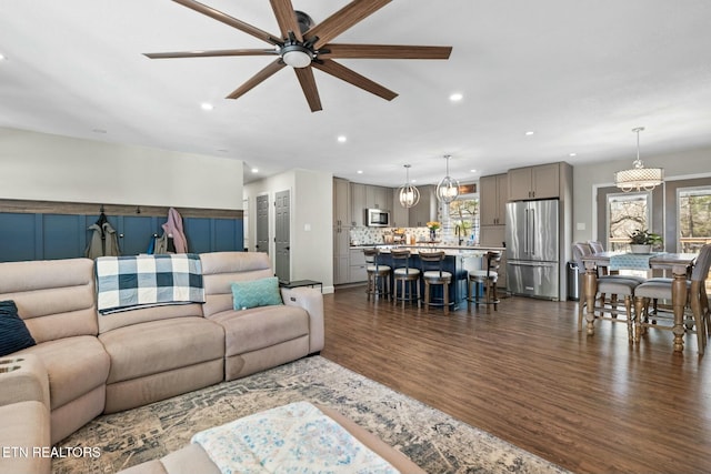 living room with sink, dark wood-type flooring, a healthy amount of sunlight, and ceiling fan