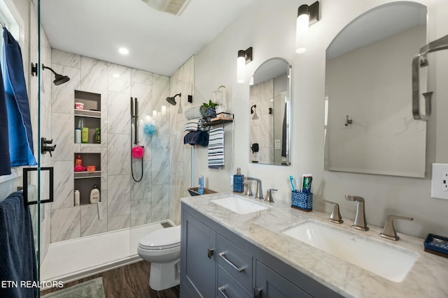 bathroom with vanity, hardwood / wood-style flooring, a shower with door, and toilet