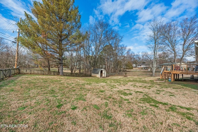 view of yard with a wooden deck and a storage shed