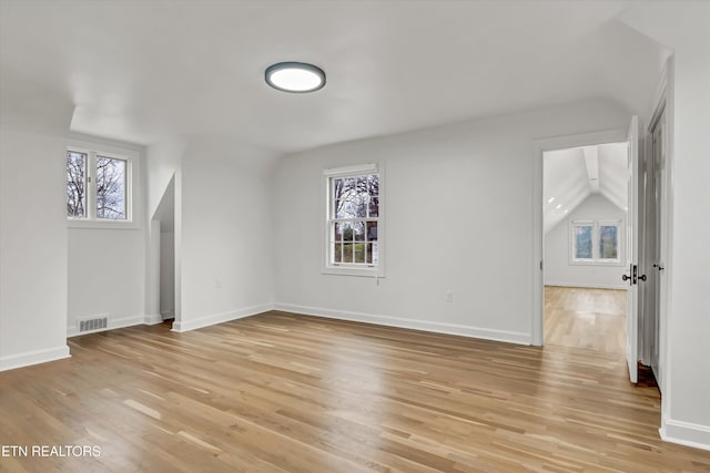 bonus room featuring light hardwood / wood-style flooring, vaulted ceiling, and plenty of natural light