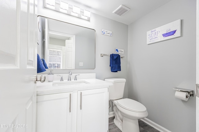 bathroom with vanity, wood-type flooring, and toilet