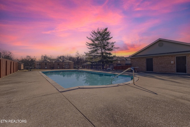 pool at dusk featuring a patio area