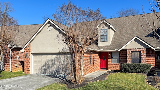 view of front facade featuring roof with shingles, brick siding, stucco siding, a garage, and driveway