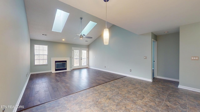 unfurnished living room with lofted ceiling with skylight, a glass covered fireplace, visible vents, and baseboards