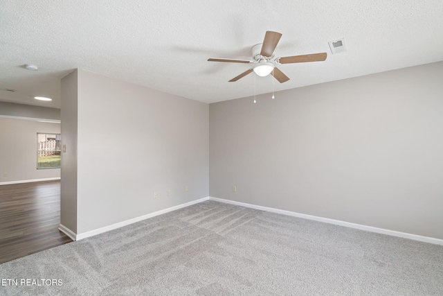 carpeted spare room featuring ceiling fan and a textured ceiling