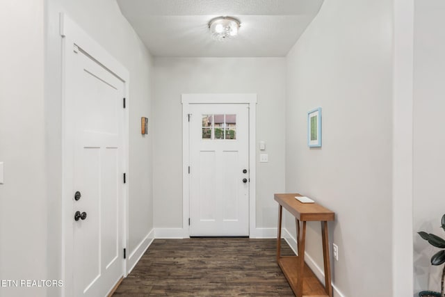 doorway to outside featuring dark wood-type flooring and a textured ceiling