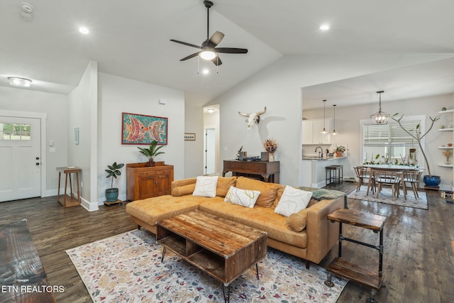 living room with dark hardwood / wood-style flooring, lofted ceiling, and ceiling fan