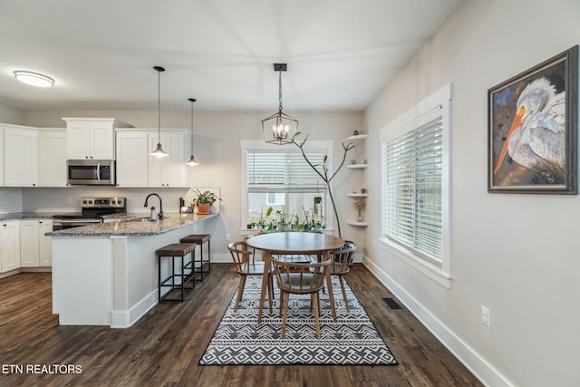 dining room with an inviting chandelier, dark hardwood / wood-style flooring, and sink