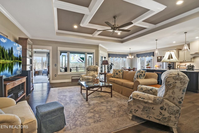 living room featuring coffered ceiling, crown molding, dark wood-type flooring, and ceiling fan with notable chandelier