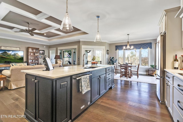 kitchen with appliances with stainless steel finishes, decorative light fixtures, sink, dark wood-type flooring, and a center island with sink