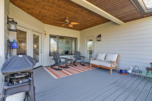 wooden terrace with ceiling fan, a grill, and an outdoor hangout area