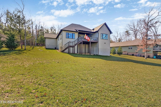 rear view of house featuring a deck and a lawn